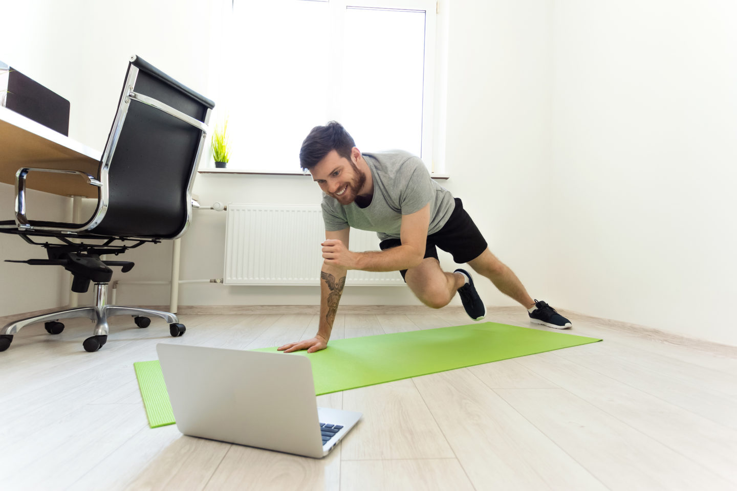 Man Doing Exercises at Home with Online Tutorial. Man Watching Laptop Doing Sports. Video Call Practice. Online Training on Quarantine at Home. Home Sport, Healthy Life, Quarantine Concept