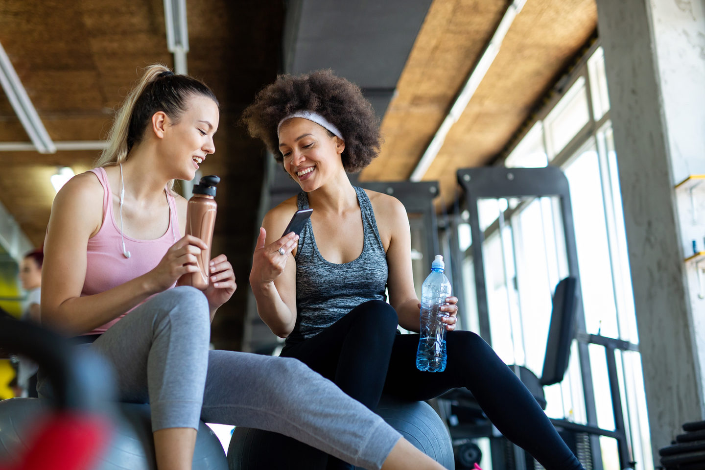 Beautiful women working out in gym together to stay healthy. Sport, people, friend concept.