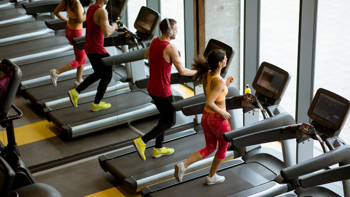 People in gym on treadmills red yellow
