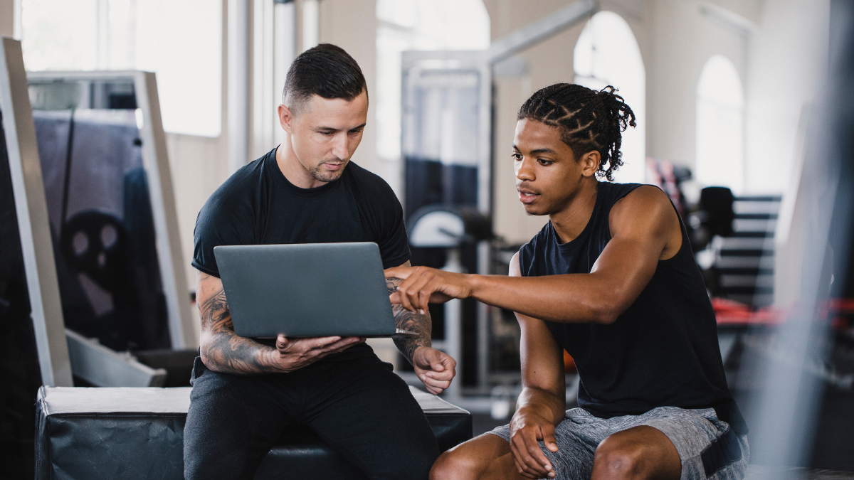 Trainer working w member using laptop